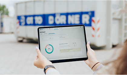 Tablet zur Digitalen Entsorgung, Otto Dörner Mulde im Hintergrund