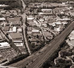 Luftaufnahme einer Stadt mit Industriegebieten und einer stark befahrenen Straße.