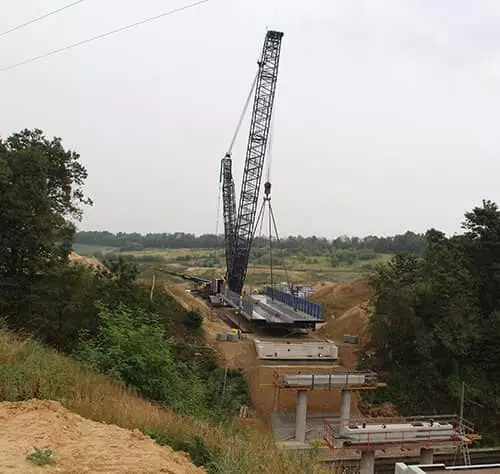 Baukran hebt Materialien auf einer Baustelle in einer ländlichen Umgebung.