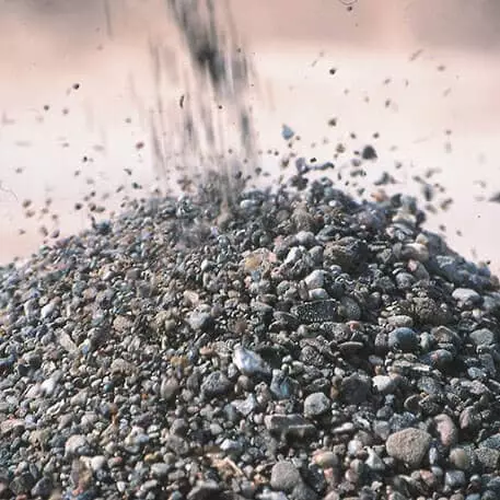 Kleine Steine und Kies werden auf einen Haufen geschüttet, ideal für Bauprojekte.