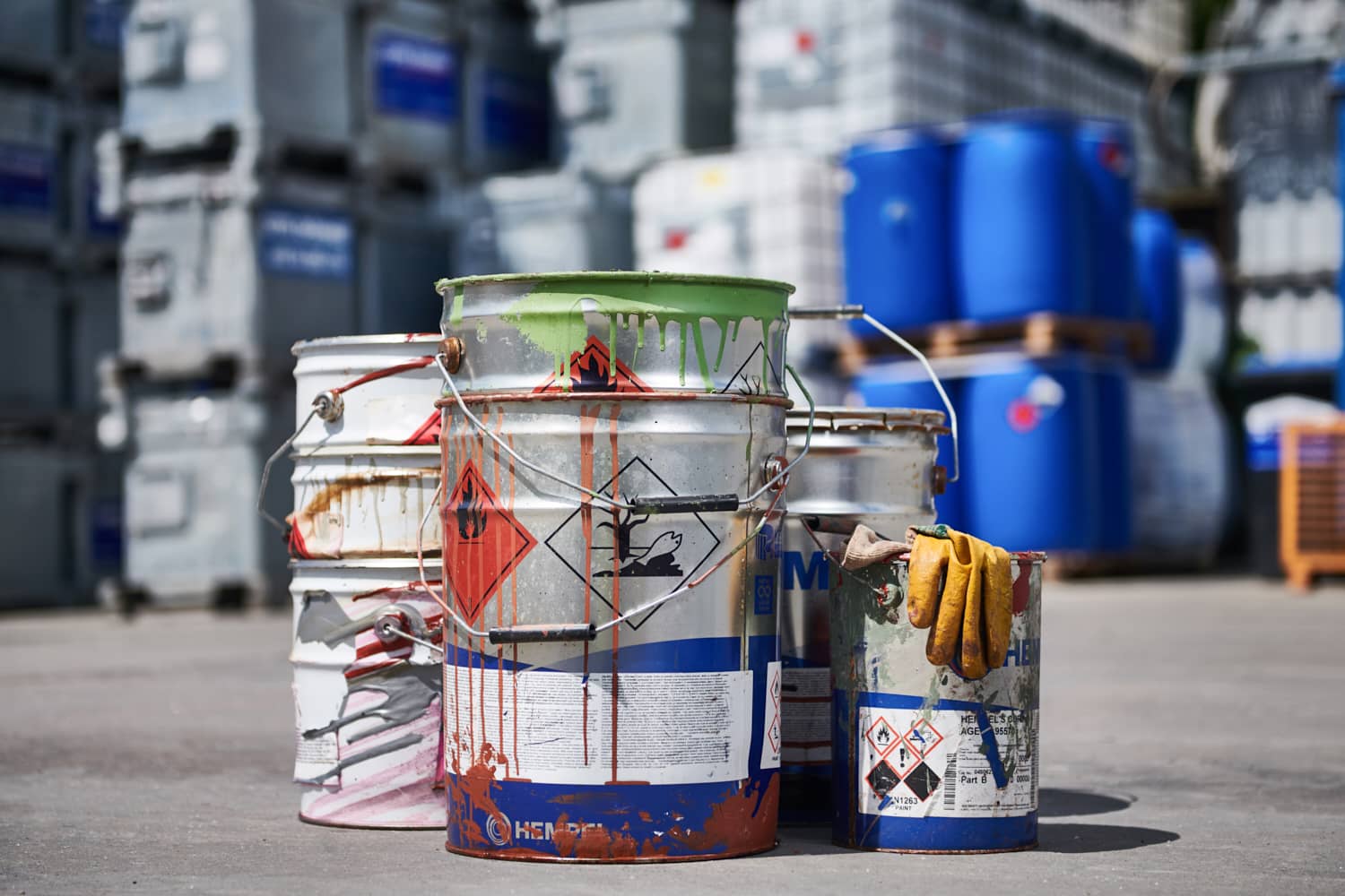 Farbbeh&auml;lter und Chemikalien in einem Lagerbereich, bereit f&uuml;r die Entsorgung oder Verwendung.