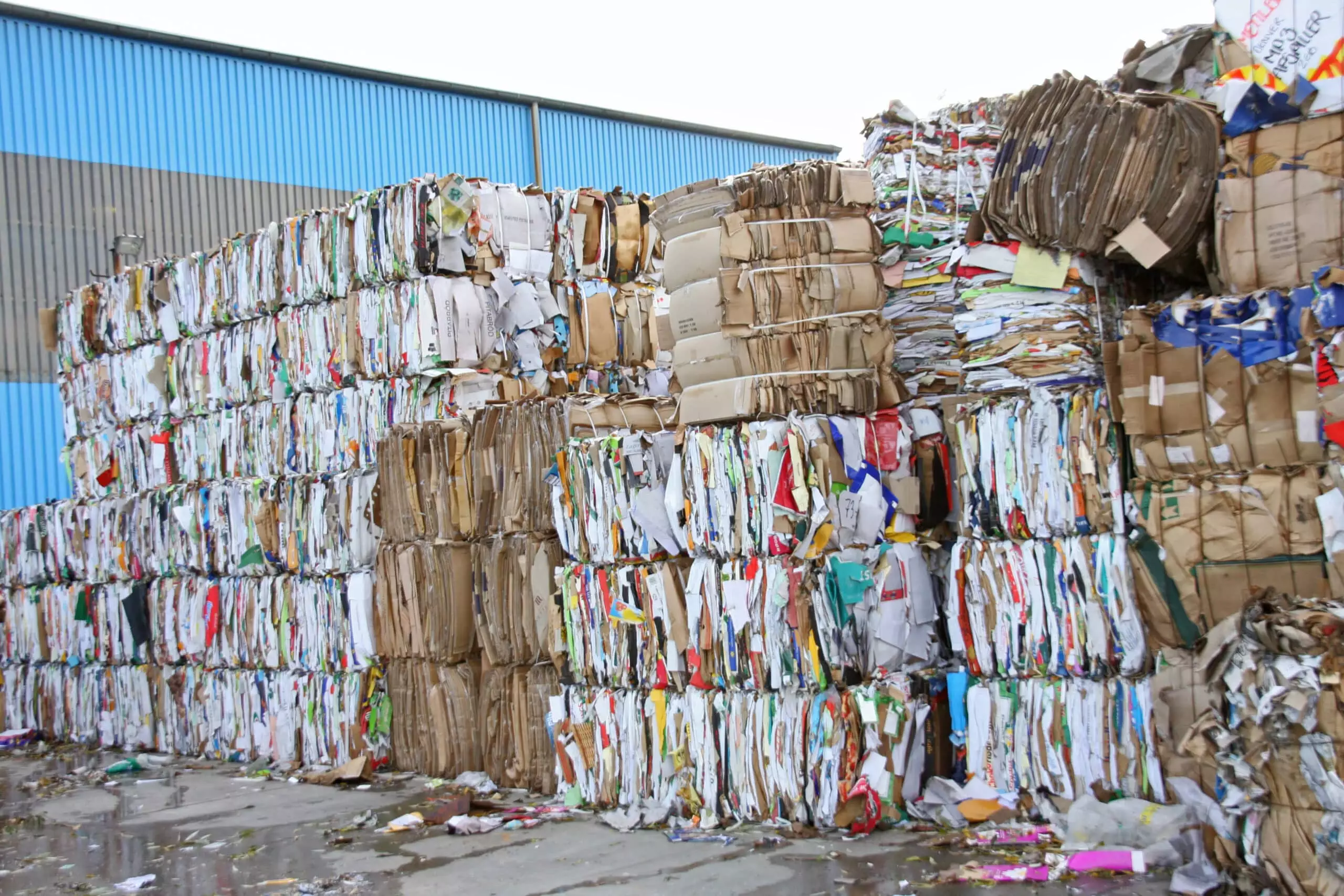 Gestapelte Papier- und Kartonb&uuml;ndel zur Wiederverwertung in einem Recyclingbetrieb.